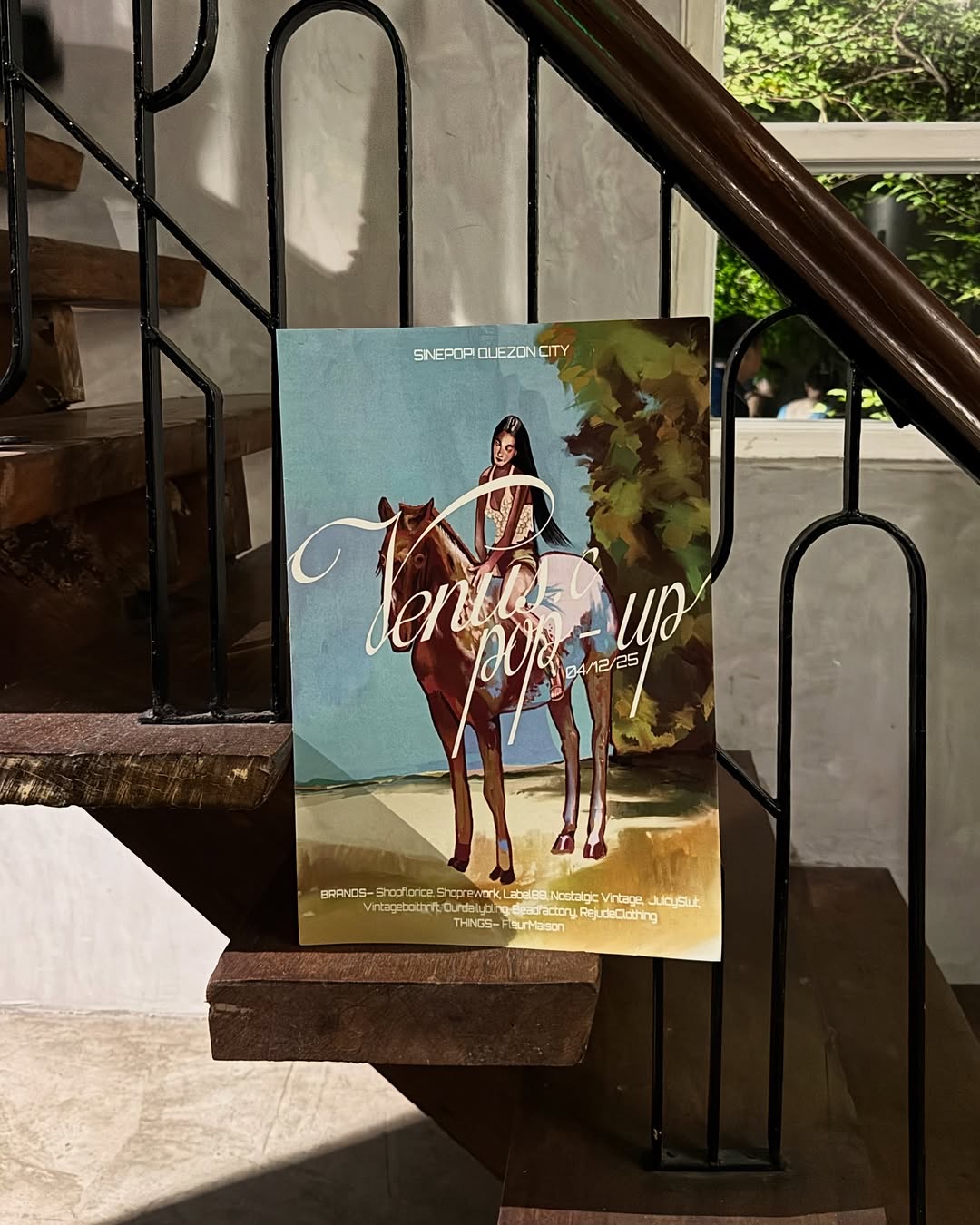 Venus Collab pop-up event poster displayed on wooden staircase